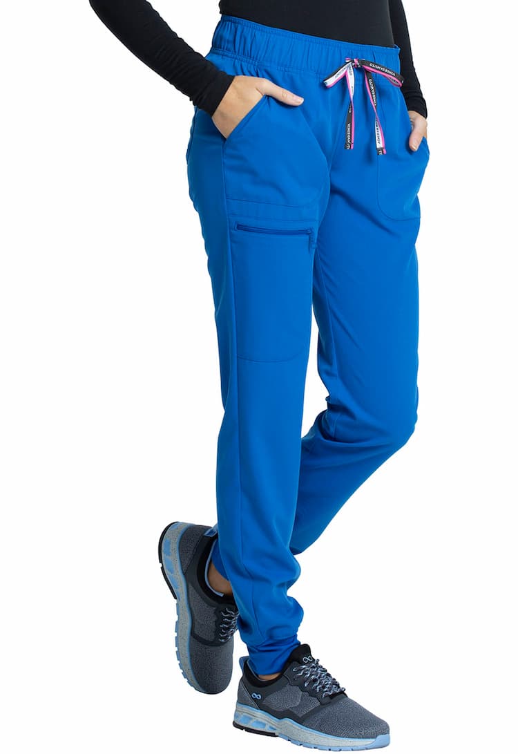 A young female Medical Assistant wearing a Vince Camuto Women's Mid Rise Drawstring Jogger in Royal size Medium featuring an outside, zipper cargo pocket on the wearer's left side.