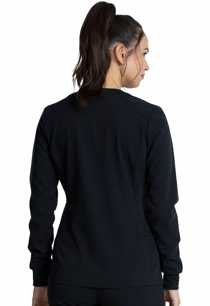 An image of a female Medical Assistant wearing a Vince Camuto Women's Zip Front Scrub Jacket in Black size Small featuring princess seams at the front & back.