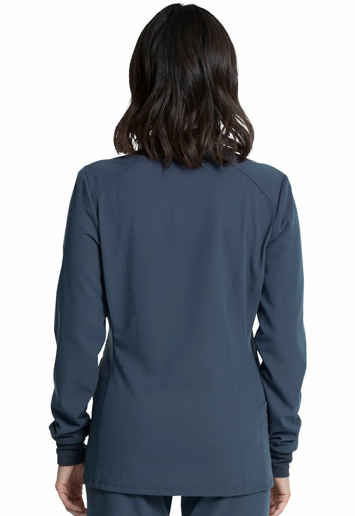 An image of a female Medical Assistant wearing a Vince Camuto Women's Zip Front Scrub Jacket in Pewter size Small featuring princess seams at the front & back.