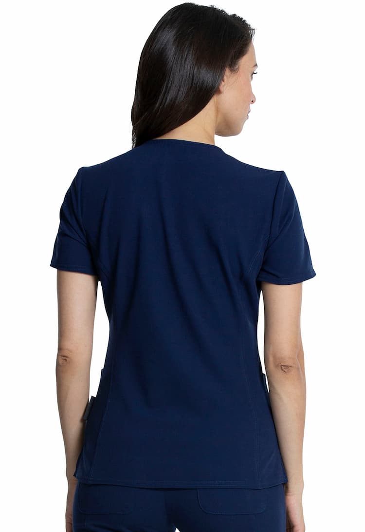 An image of a young female Physical Therapist wearing a Vince Camuto Women's V-Neck Scrub Top in Navy size Medium featuring a center back length of 26".