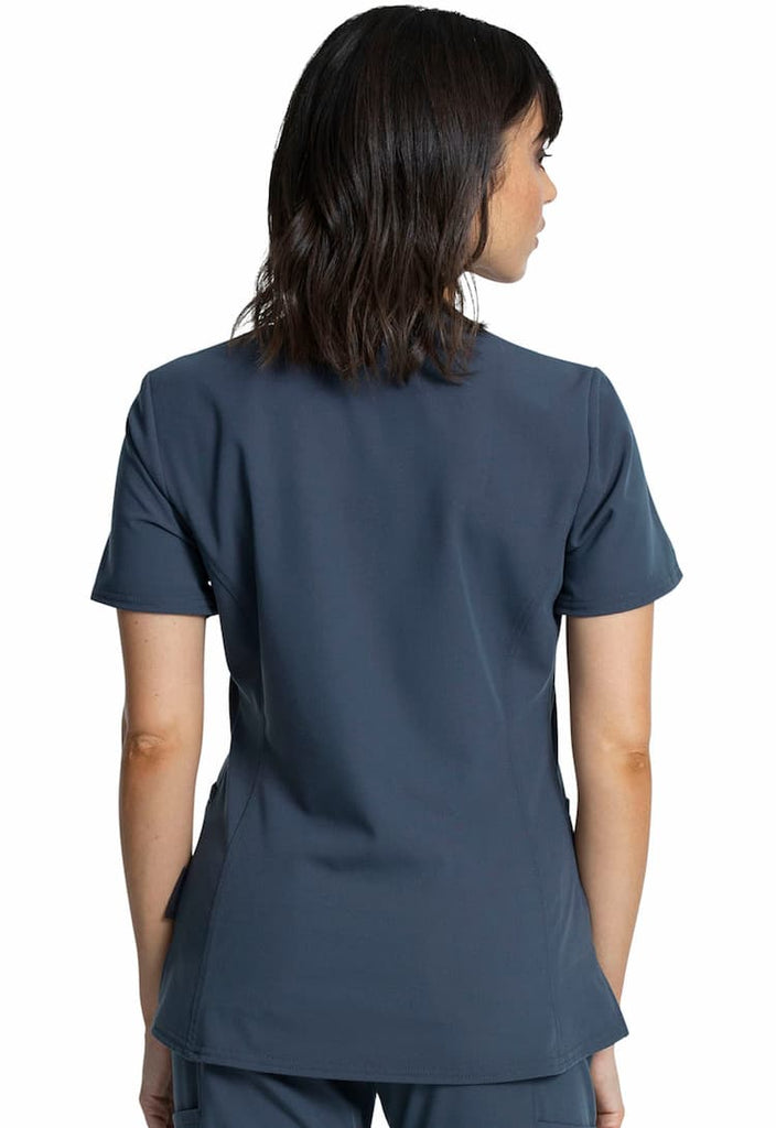 An image of a young female Physical Therapist wearing a Vince Camuto Women's V-Neck Scrub Top in Pewter size Medium featuring a center back length of 26".