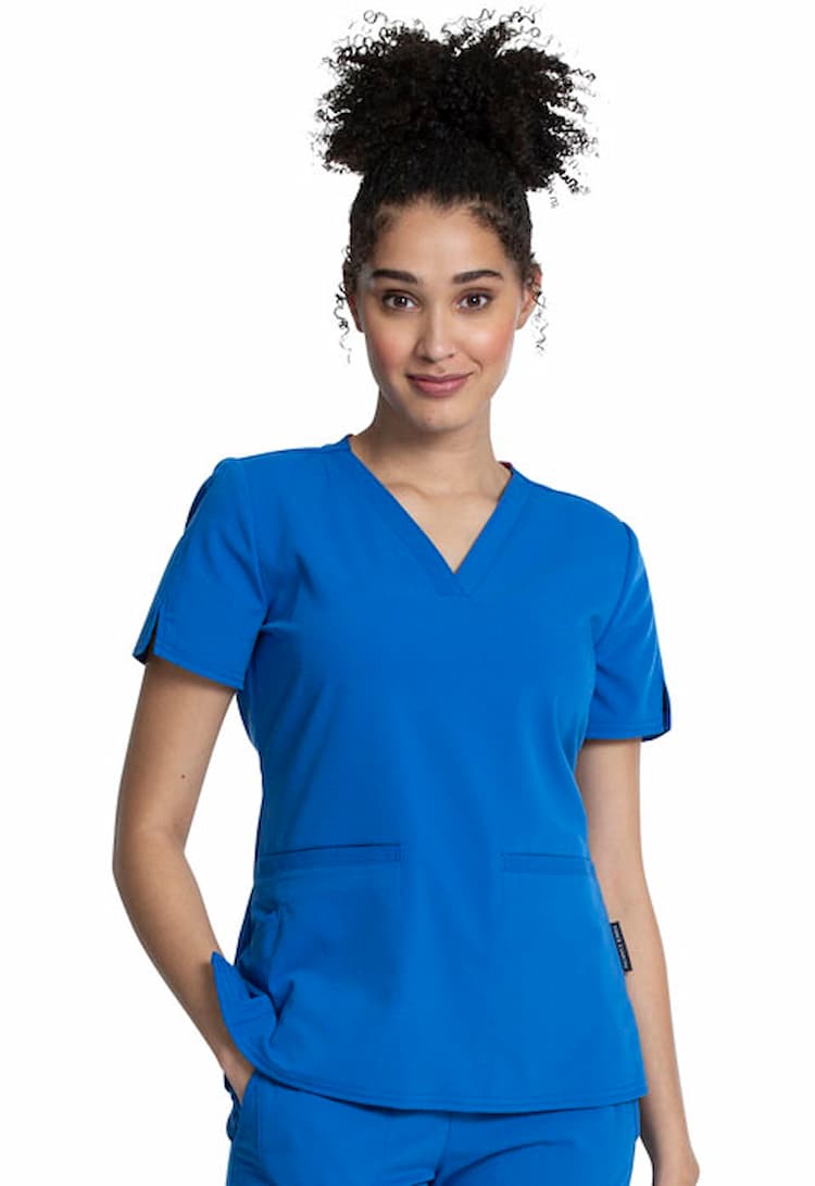  A young female Registered Nurse wearing a Vince Camuto Women's V-neck Scrub Top in Royal Blue size XS featuring 2 front patch pockets.