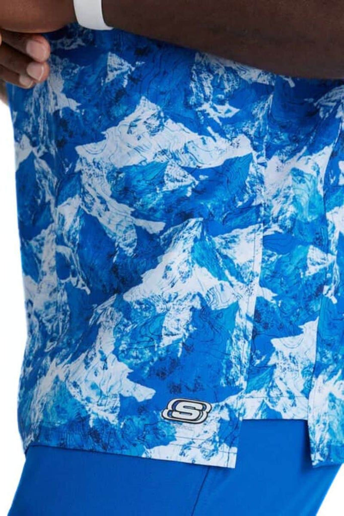 A close look at the left side of the Skechers Men's Structure Crossover V-Neck Top in Arctic Landscape featuring the Skechers logo in the bottom left corner of the front of the shirt.