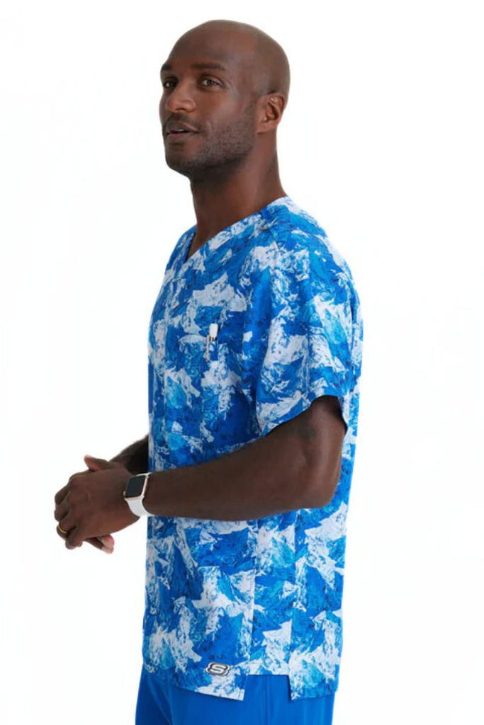 A young male Veterinarian wearing a Skechers Men's Structure Crossover V-Neck Top in "Arctic Landscape" featuring side vents for enhanced breathability and range of motion, keeping you cool and comfortable.