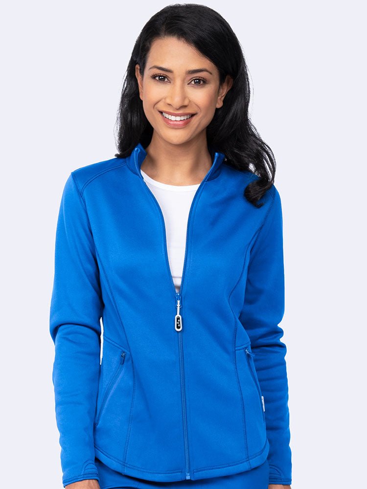 Young female healthcare professional wearing an Ava Therese Women's Bonded Fleece Jacket in Royal featuring a soft, light fleece with an anti-static finish.