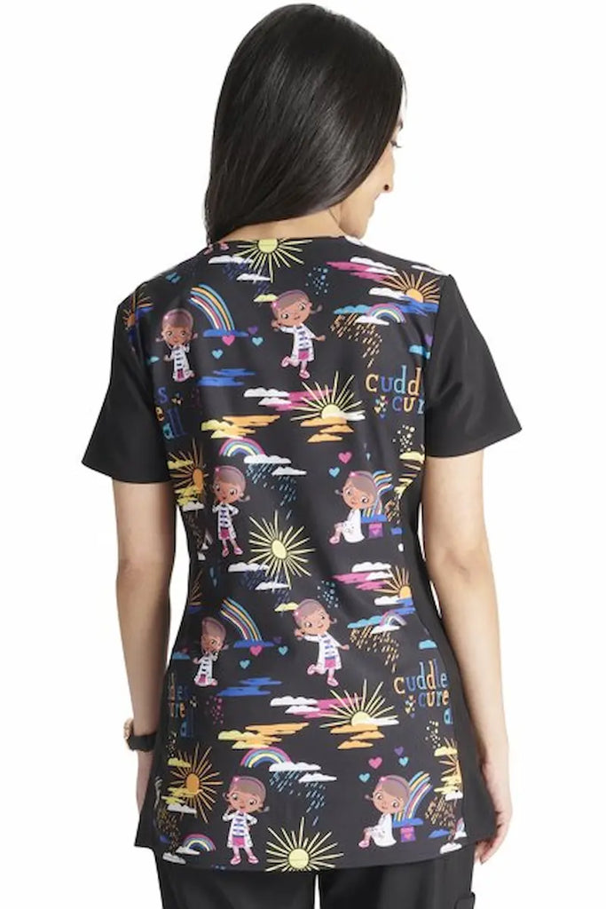 An image of the back of a Neonatal Nurse wearing a Tooniforms Women's V-neck Printed Scrub Top in "Cuddles Cure All" size Medium featuring a soft and breathable fabric made of 55% cotton and 45% polyester.