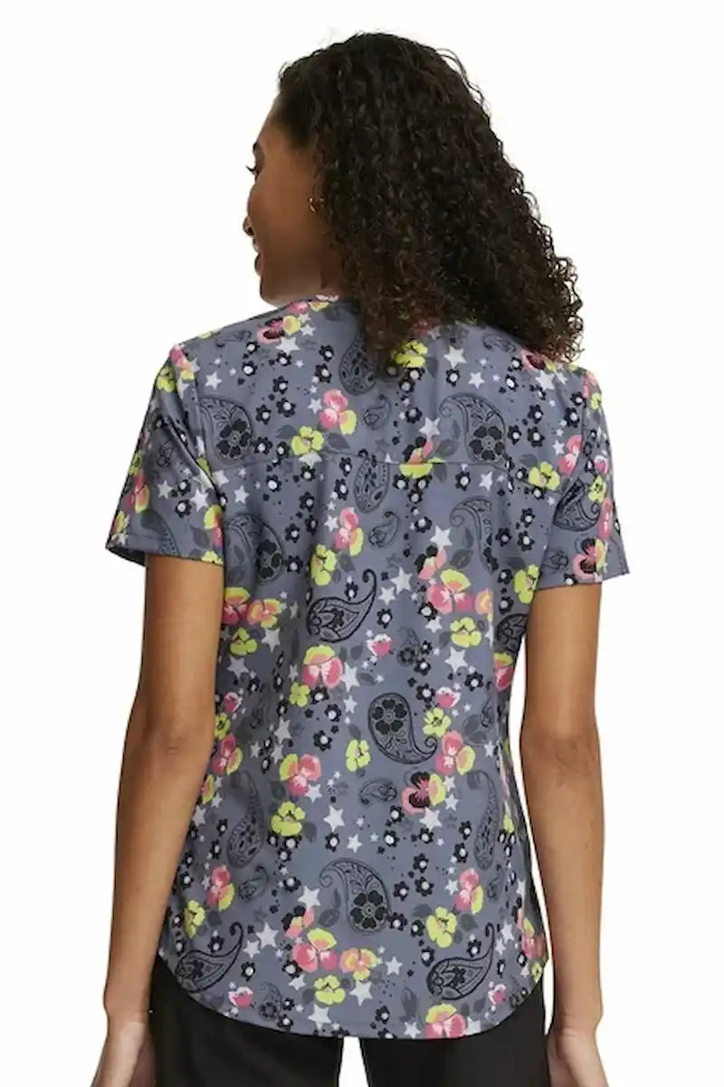 A young female Neonatal Nurse wearing a Cherokee Woman's V-neck Printed Scrub in "Paisley Petals" size Medium featuring a center back length of 26".