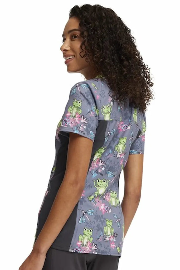 A young female Neonatal Nurse Wearing a Cherokee iFlex Women's V-neck Knit Panel Top in "Toad-ally Floral Friends" size Small featuring a center back length of 26" for optimal coverage.