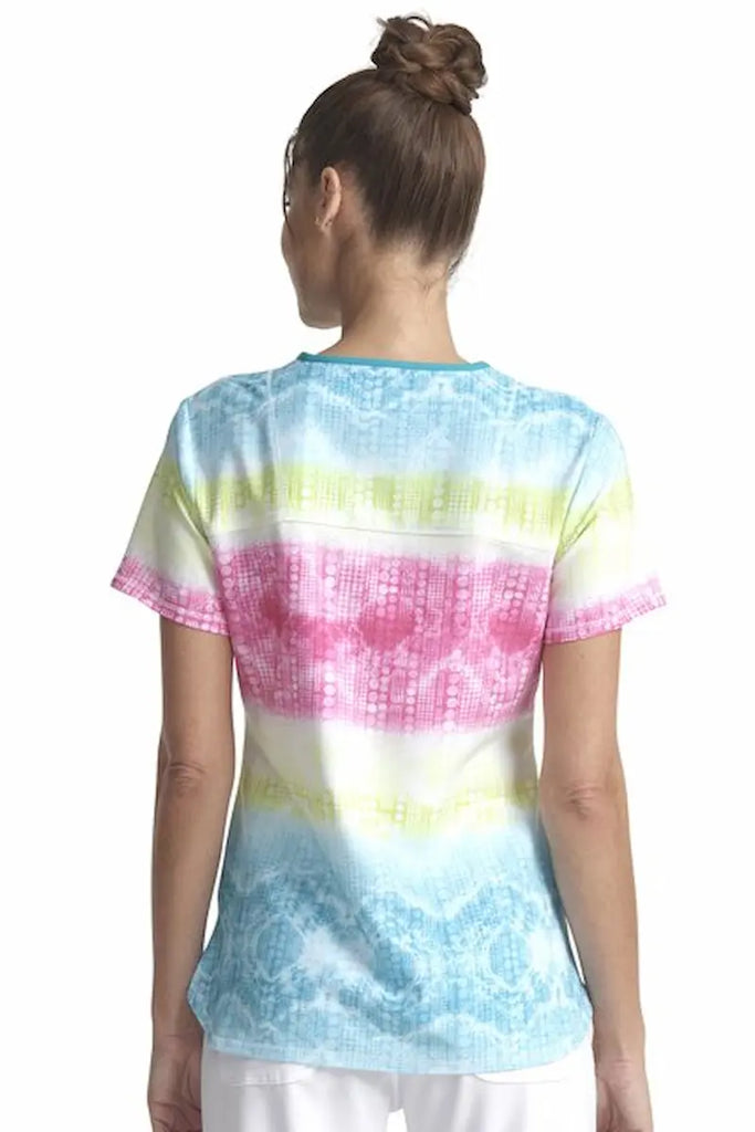 A young female Psychiatric Nurse wearing a Cherokee Women's V-neck Printed Scrub Top in "Trippy Stripes" size Large featuring a center back length of 26". 