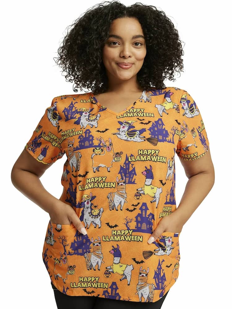 A young female Pediatric Nurse wearing a Cherokee Women's V-Neck Printed Scrub Top in "Happy Llamaween"  featuring two front patch pockets.
