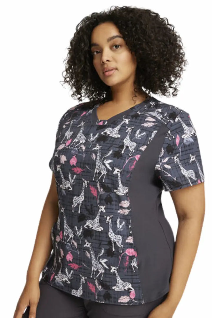 A look at the left side of the Cherokee iFlex Women's Knit Panel Print Scrub Top in "Giraffe-ter Love" featuring knit side panels.