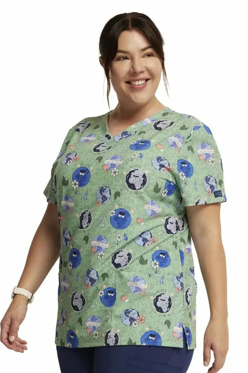 A look at the side of the Dickies Women's V-Neck Print Scrub Top in Happy To Be Here featuring side vents for additional range of motion.