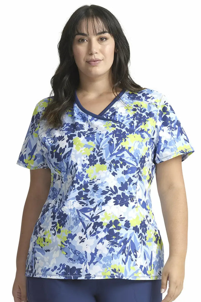 A young female Psychiatric Nurse wearing a Cherokee Infinity Women's Mock Wrap Printed Scrub Top in "Brushstroke Buds" size 3XL featuring a modern classic fit.