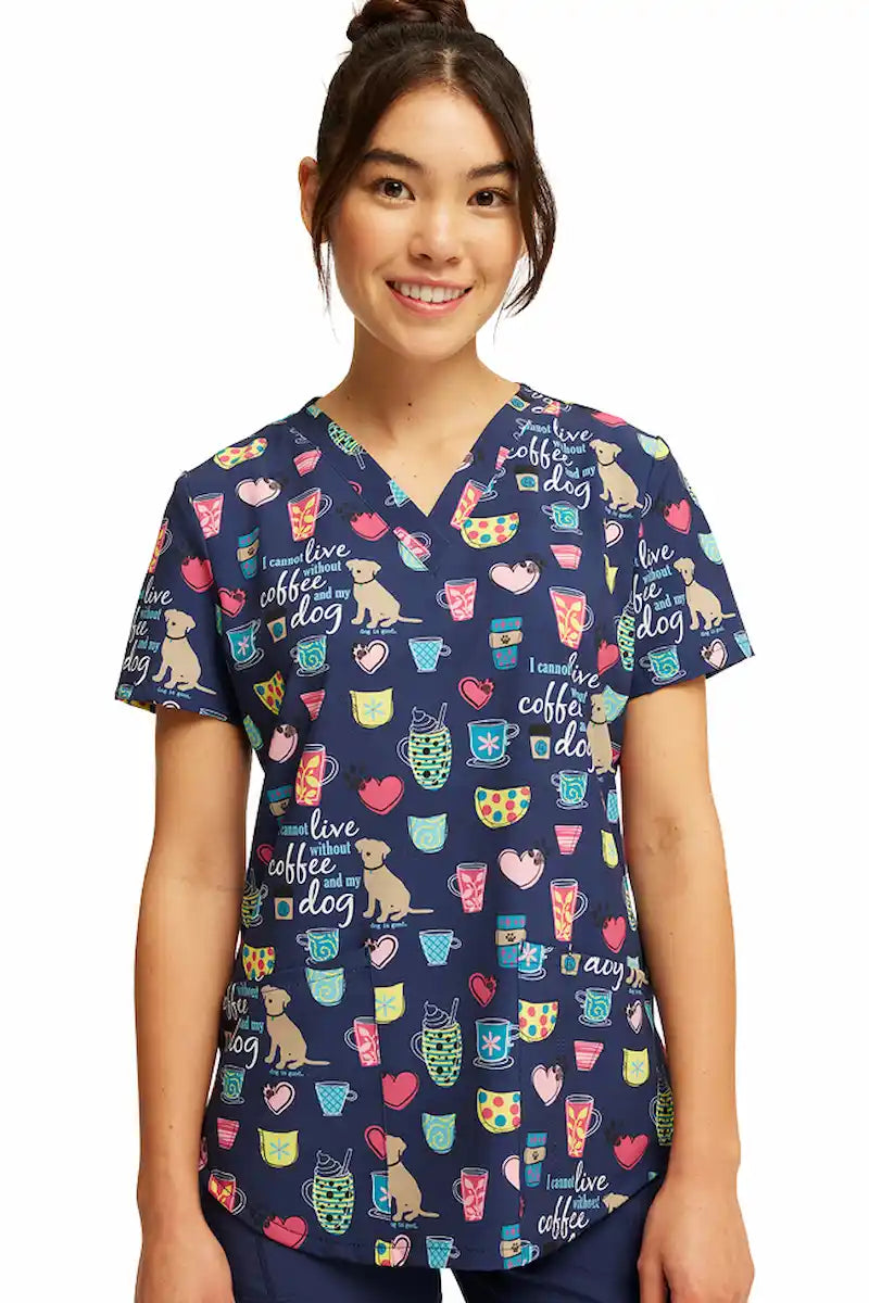 A young female Veterinarian wearing a Cherokee Women's V-neck Printed Scrub Top in "Coffee and My Dog" size XS featuring a Modern Classic Fit.