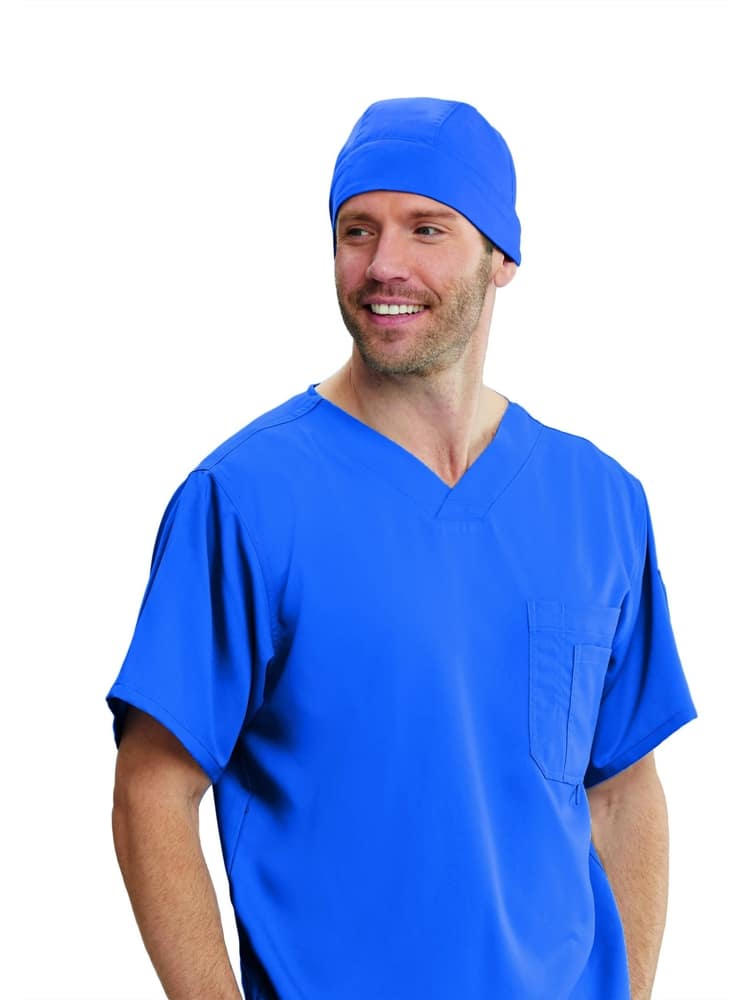 A young male Phlebotomist wearing a Grey's Anatomy Unisex Fitted Scrub Cap in Royal Blue featuring a self tie at the back.