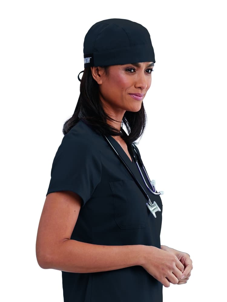 A young female Surgeon wearing a Grey's Anatomy Unisex Fitted Scrub Cap in Steel Grey featuring a self tie at the back to ensure a perfect all day fit.