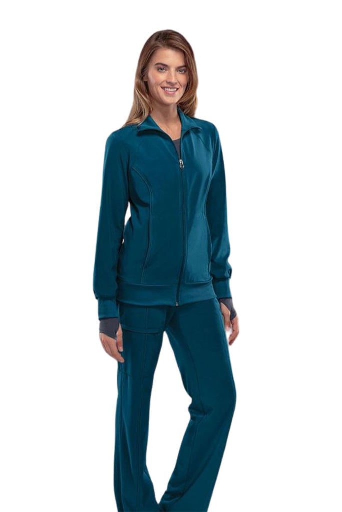 A young female Phlebotomist wearing a Cherokee Infinity Women's Antimicrobial Warm Up Jacket in Caribbean size XL featuring a zip front & a moisture wicking fabric.