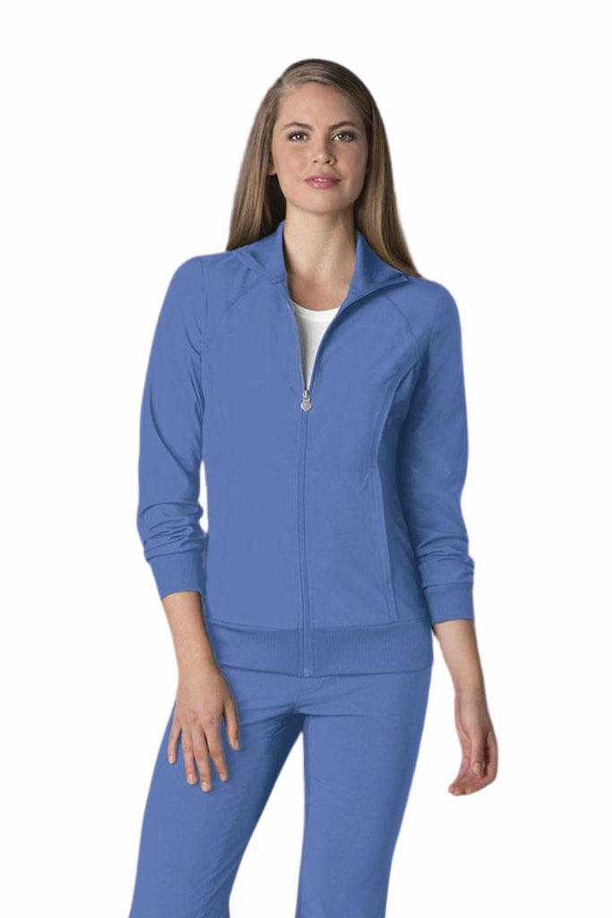 A young female Dental Hygienist wearing a Cherokee Infinity Women's Antimicrobial Warm Up Jacket in Ceil size medium featuring a zip front & a moisture wicking fabric.