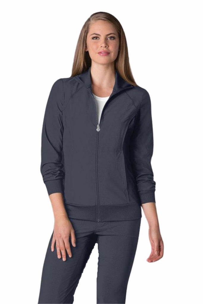 A young female Dermatologist wearing a Cherokee Infinity Women's Antimicrobial Warm Up Jacket in Pewter size medium featuring a zip front & a moisture wicking fabric.