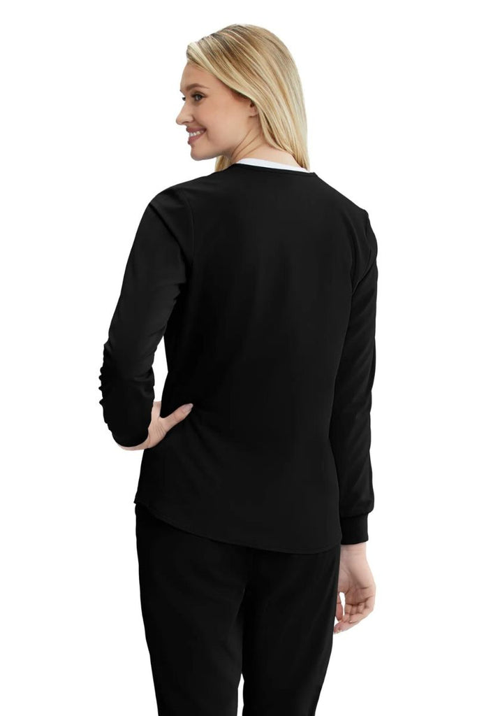The back of the Skechers Women's Stability Snap Front Scrub Jacket in Black featuring a curved hemline.