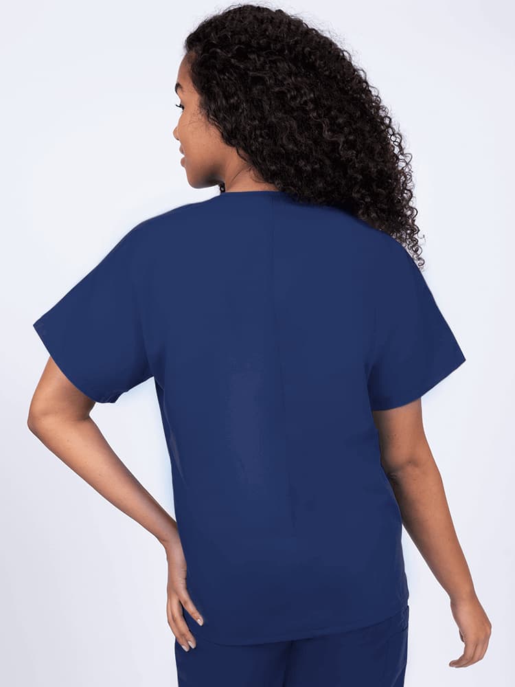 A young female Nurse wearing a Luv Scrubs Unisex Single Pocket V-Neck Scrub Top in Navy with a center back length of 27.5".