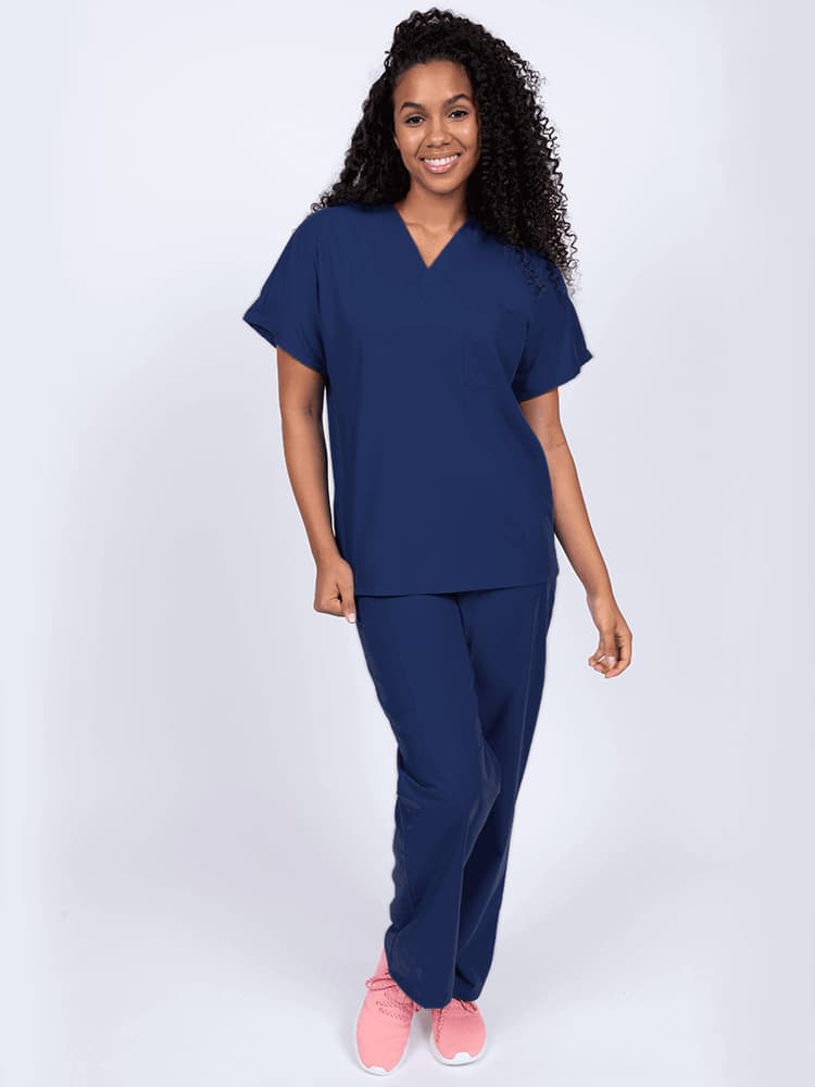 A young female Physical Therapist wearing a Luv Scrubs Unisex Single Pocket Scrub Top in Navy featuring a V-neckline.