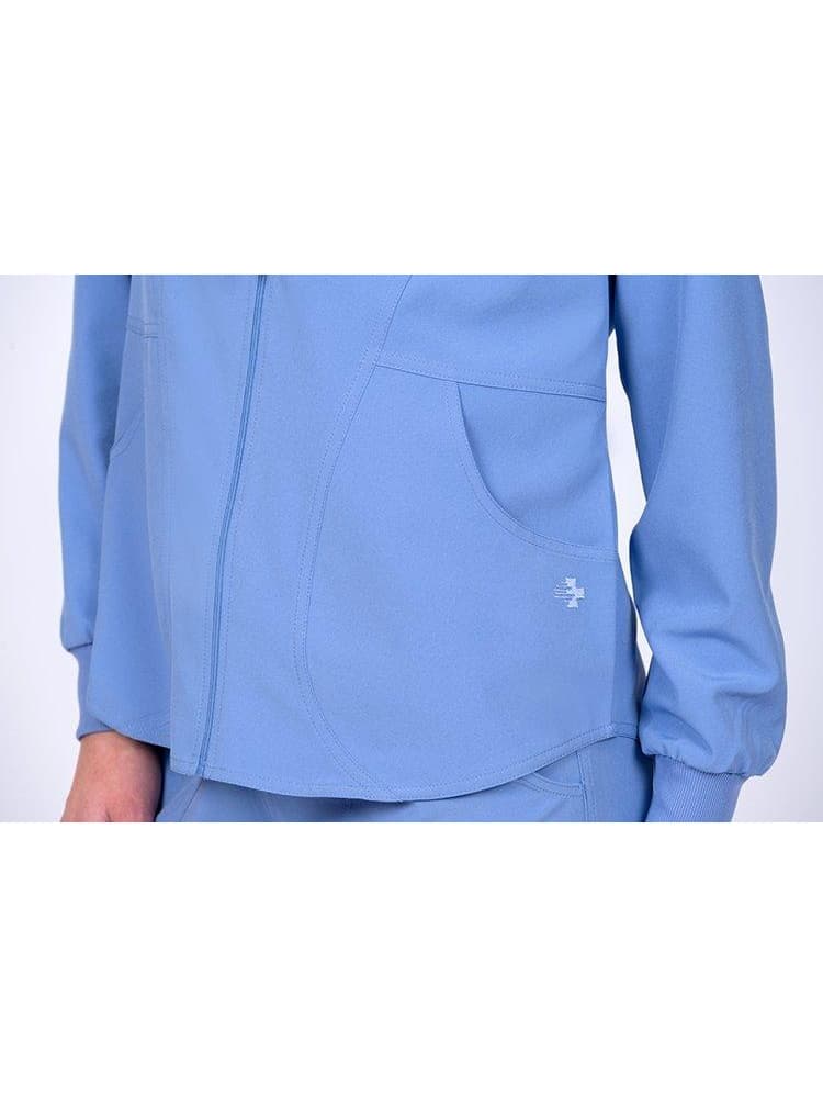 An up-close image of the Meraki Sport Women's Zip Front Scrub Jacket in Ceil size Large featuring 2 front curved pockets.