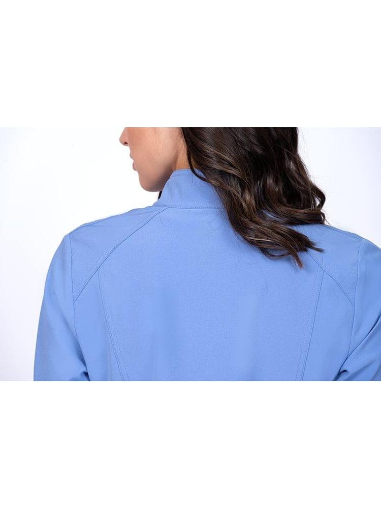 An up-close image of a young female RN wearing a Meraki Sport Women's Zip Front Jacket in Ceil size Medium featuring a unique 4-way stretch fabric.