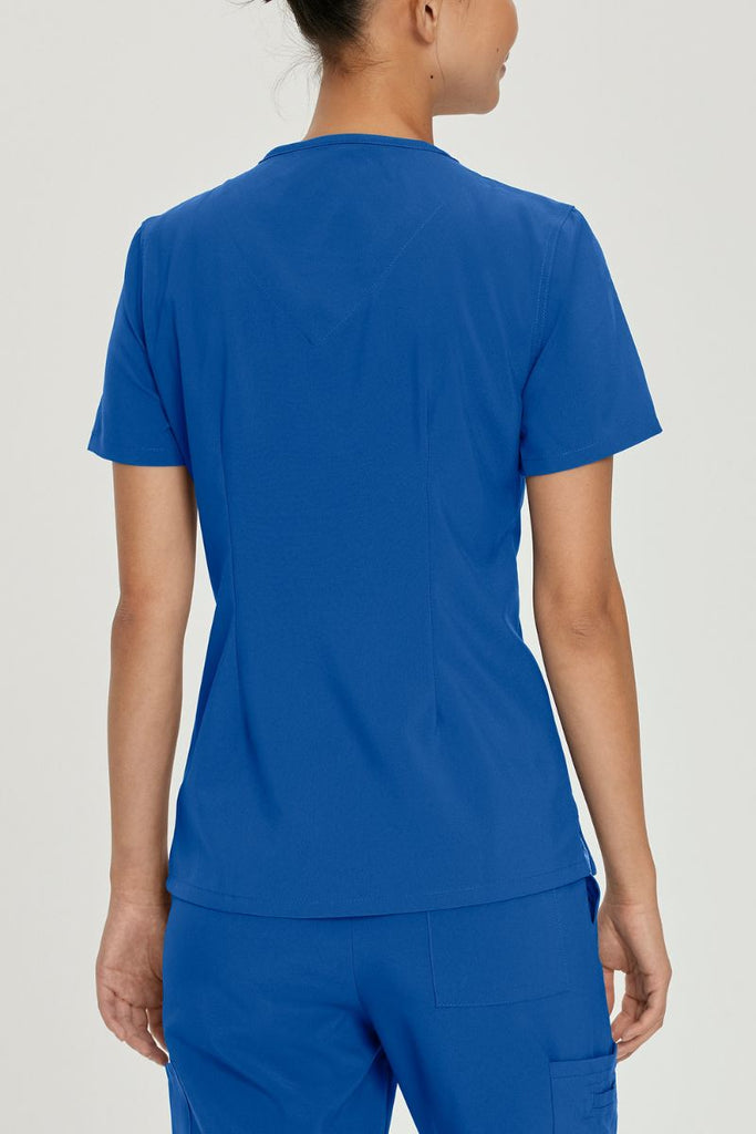 A young female LVN wearing an Urbane Performance Women's Motivate V-neck Scrub Top in New Royal size Medium featuring a center back length of 26.5"