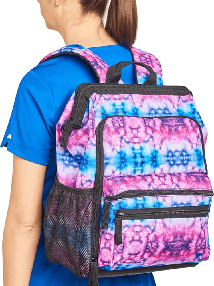 An image of a young female nures wearing a Nursemates Ultimate Backpack in "Berry Blue Tie Dye" featuring adjustable back straps to ensure a comfortable fit.