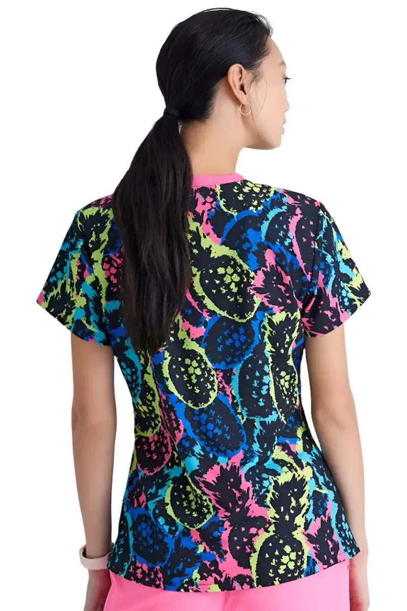 A young female children's nurse showcasing the back of the Skechers Women's V-Neck Scrub Top in Pineapple Pop featuring a center back length of 26".