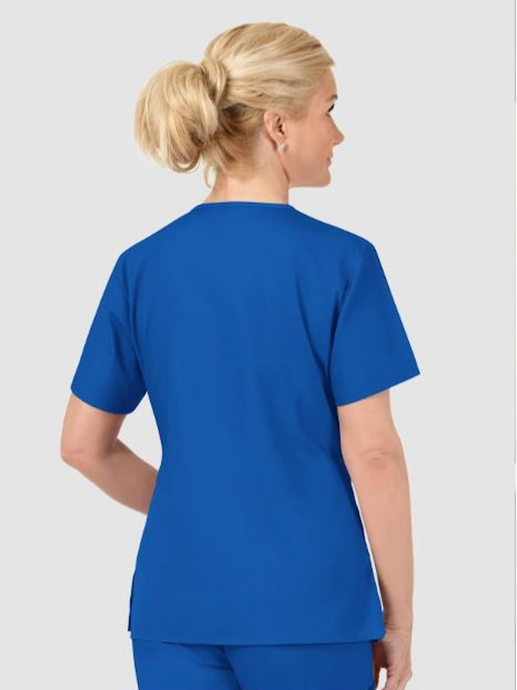 A middle aged female Nursing Assistant wearing a WonderWink Origins Women's Bravo V-Neck Scrub Top in Royal size Medium featuring a soft poly cotton blend.
