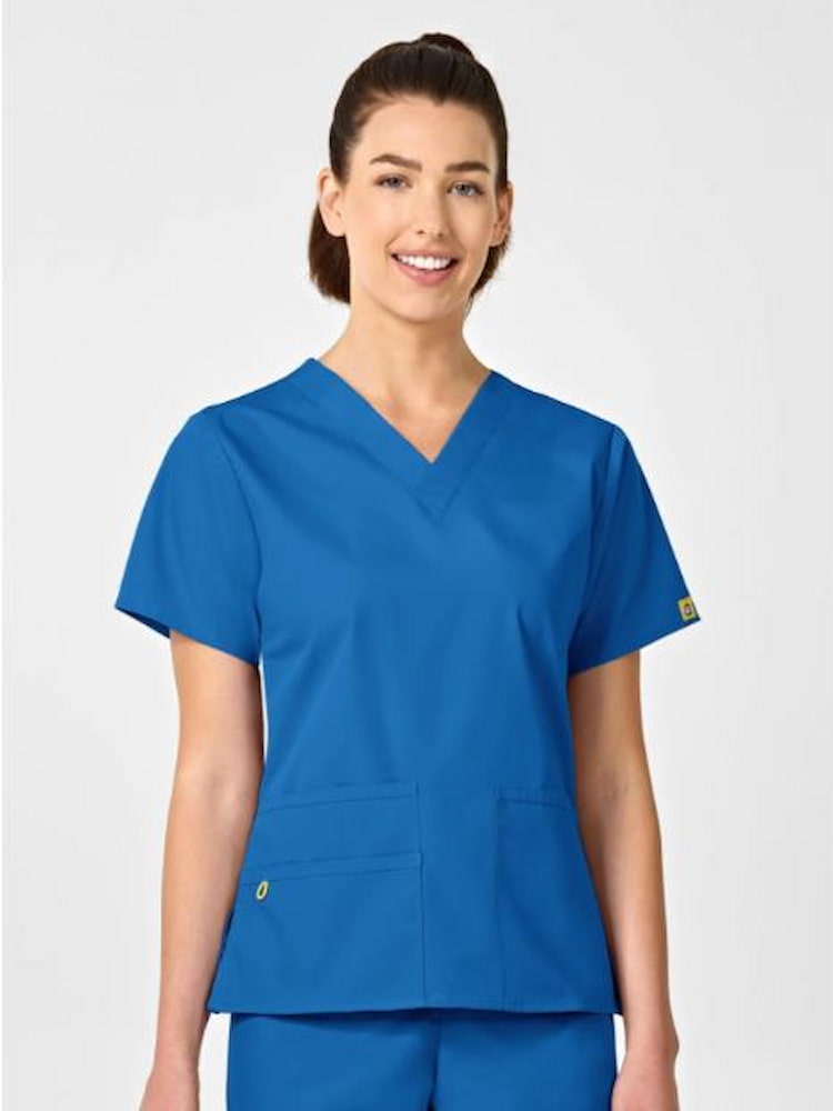 An image of a young female Physical Therapist wearing a WonderWink Women's Bravo V-neck Scrub Top in Royal size XL featuring short sleeves and vented sides.