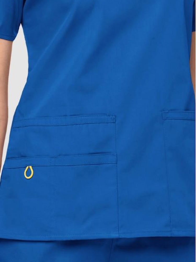 An up close image of the two lower pockets including one WonderWink signature triple pocket with hidden mesh pocket & signature ID bungee loop pn the WonderWink Origins Women's Bravo V-Neck Scrub Top.