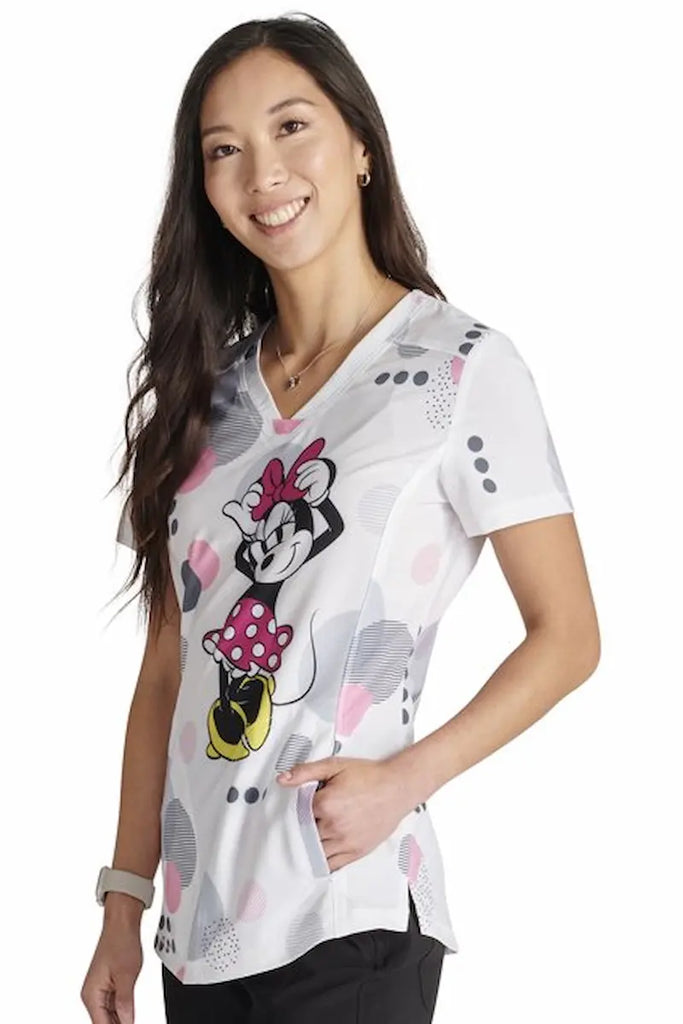 An image of a Pediatric Nurse wearing a Tooniforms Women's V-neck Printed Scrub Top in "Running in Circles" 2 front pockets for ample storage space. 