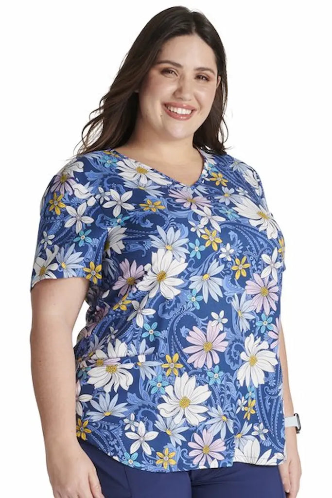 A young female Oncology Nurse wearing a Cherokee Women's V-neck Print Scrub Top in "Prairie Paisley" size Medium featuring a soft and durable blend made out of 91% polyester and 9% spandex poplin.