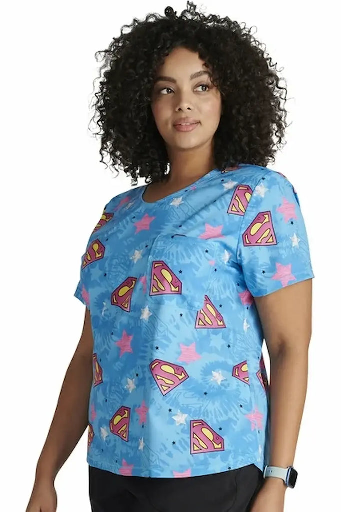 A young female LPN wearing a Tooniforms Women's V-neck Printed Scrub Top in "Symbol of Hope" size Medium featuring a curved hemline.