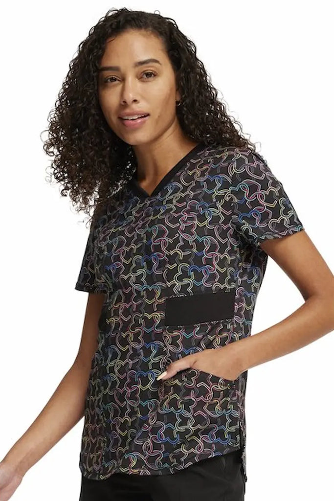 An image of the side of the Cherokee Infinity Women's V-neck Printed Scrub Top in "Links of Love"  size XL featuring 2 front in-seam pockets.