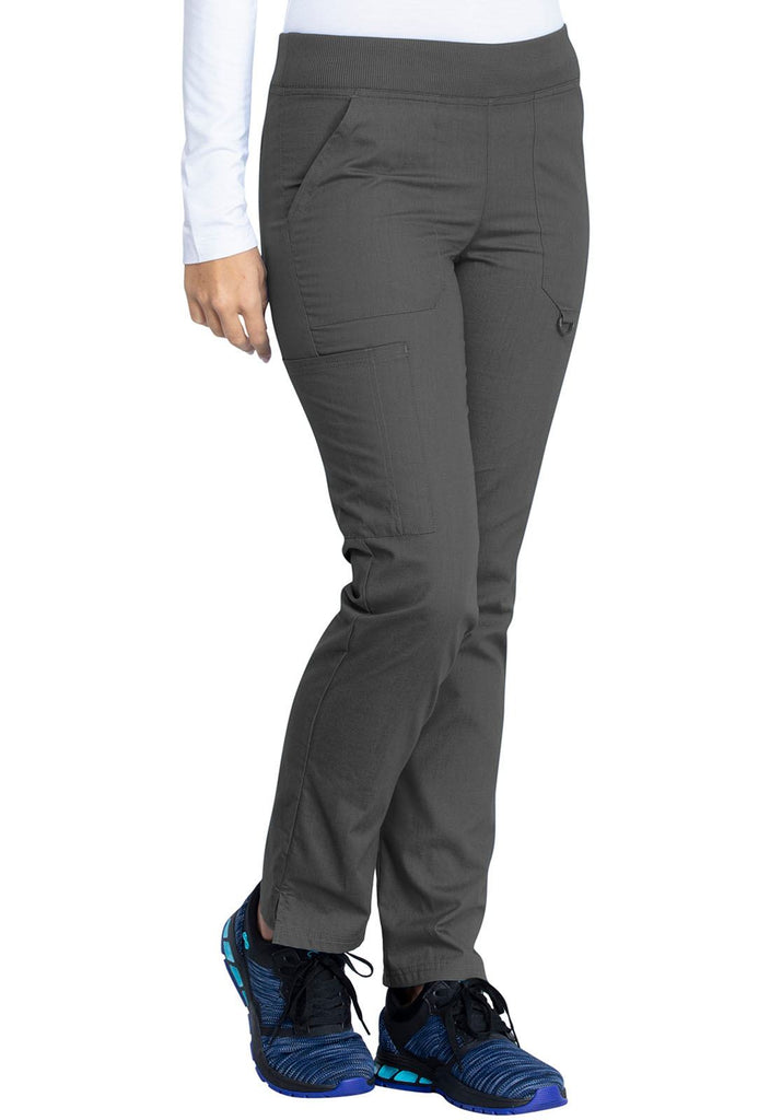 A young female LPN wearing a pair of DIckies EDS Signature Women's Mid Rise Tapered Pull-on Pant in Pewter size XL featuring side slits for easy removal & slip on.