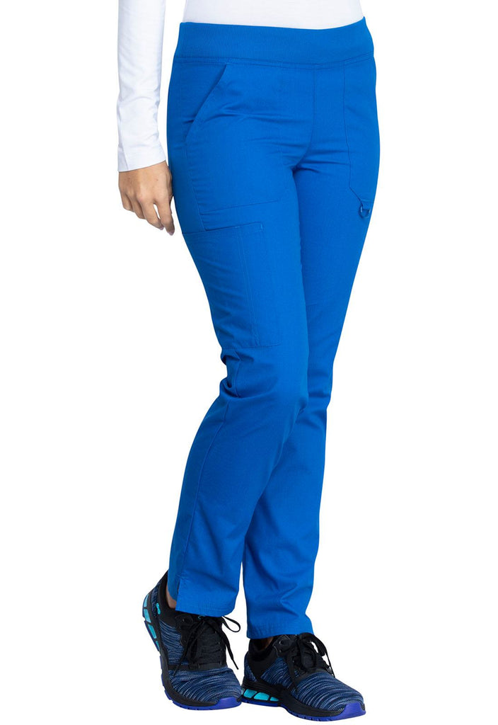 A young female LPN wearing a pair of DIckies EDS Signature Women's Mid Rise Tapered Pull-on Pant in Royal size XL featuring side slits for easy removal & slip on.