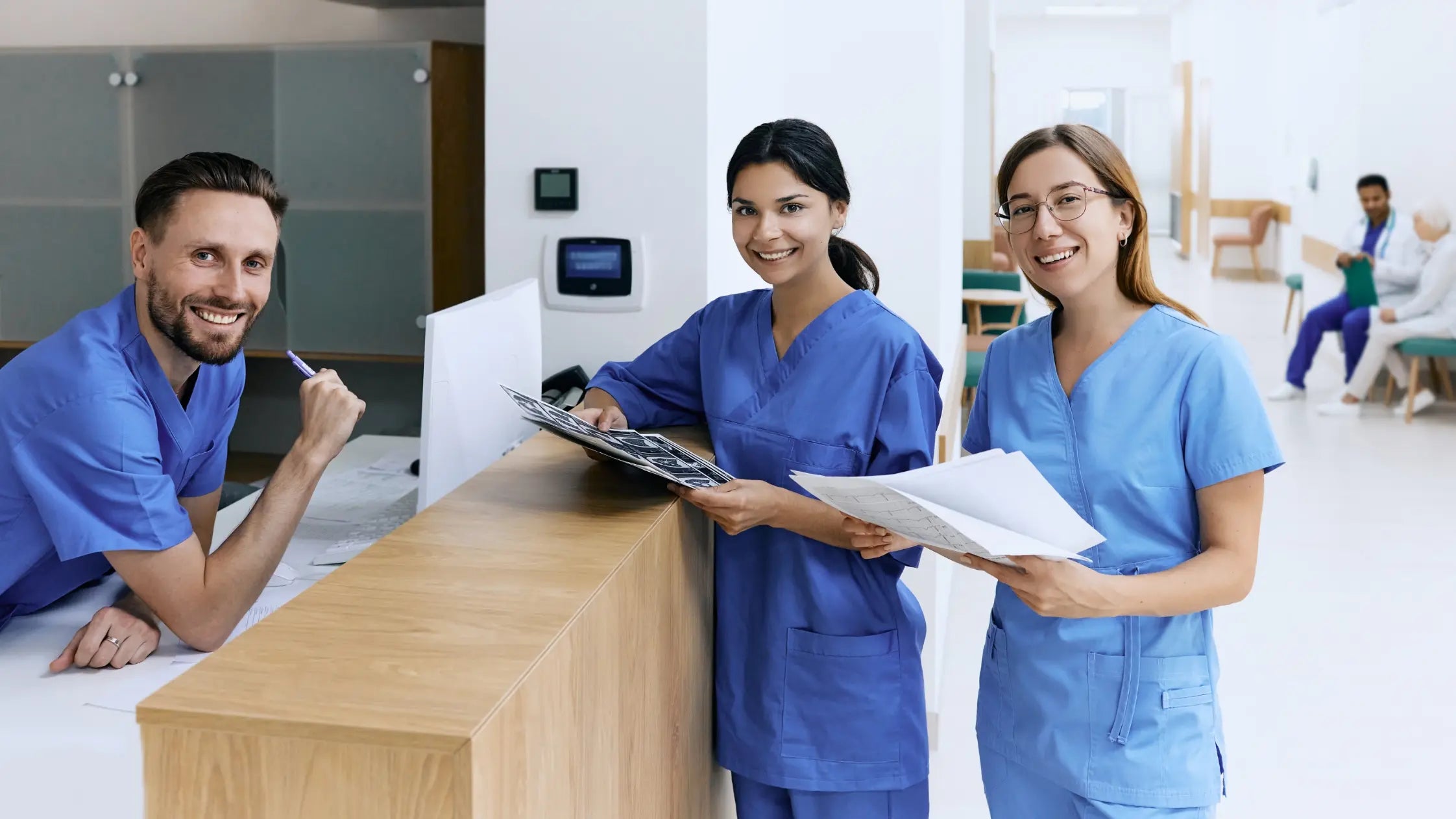 Three Healthcare Administrators in a Hospital wearing Navy Blue Medical Scrubs.