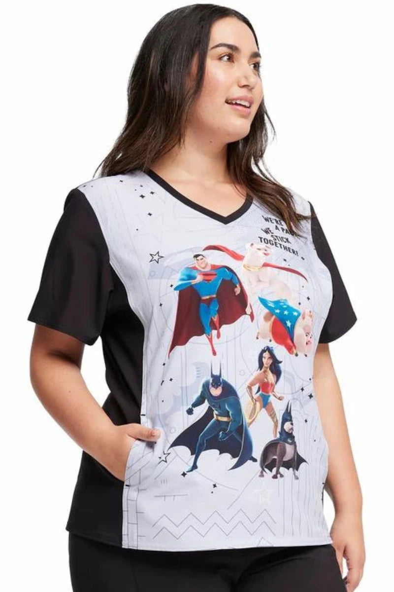 A young female nurse displaying the right side of the Tooniforms Women's V-Neck Print Scrub Top in Super Pets featuring two vertical front in-seam pockets.