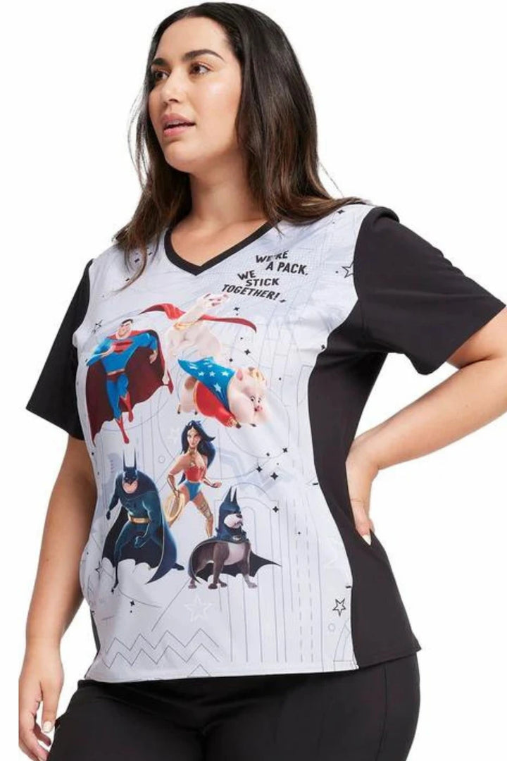 A young female Pediatric Nurse displaying the left side of the Tooniforms Women's V-Neck Print Scrub Top in Super Pets on a white background.