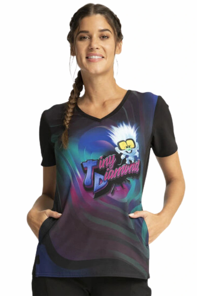 A young female Pediatric Nurse displaying the front of the Tooniforms Women's V-Neck Print Scrub Top in "Tiny Diamond" on a white background.