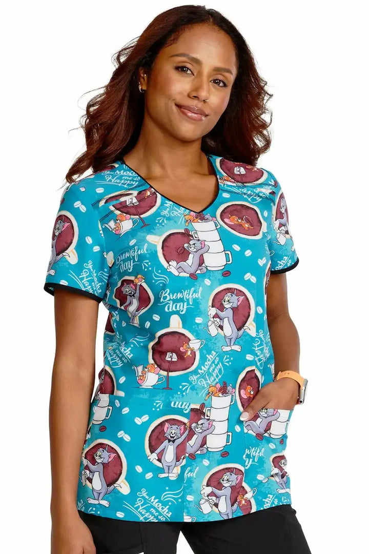 A look at the right of the Mocha Me Happy Tooniforms Women's V-Neck Print Scrub Top featuring a v-neckline and short sleeves.