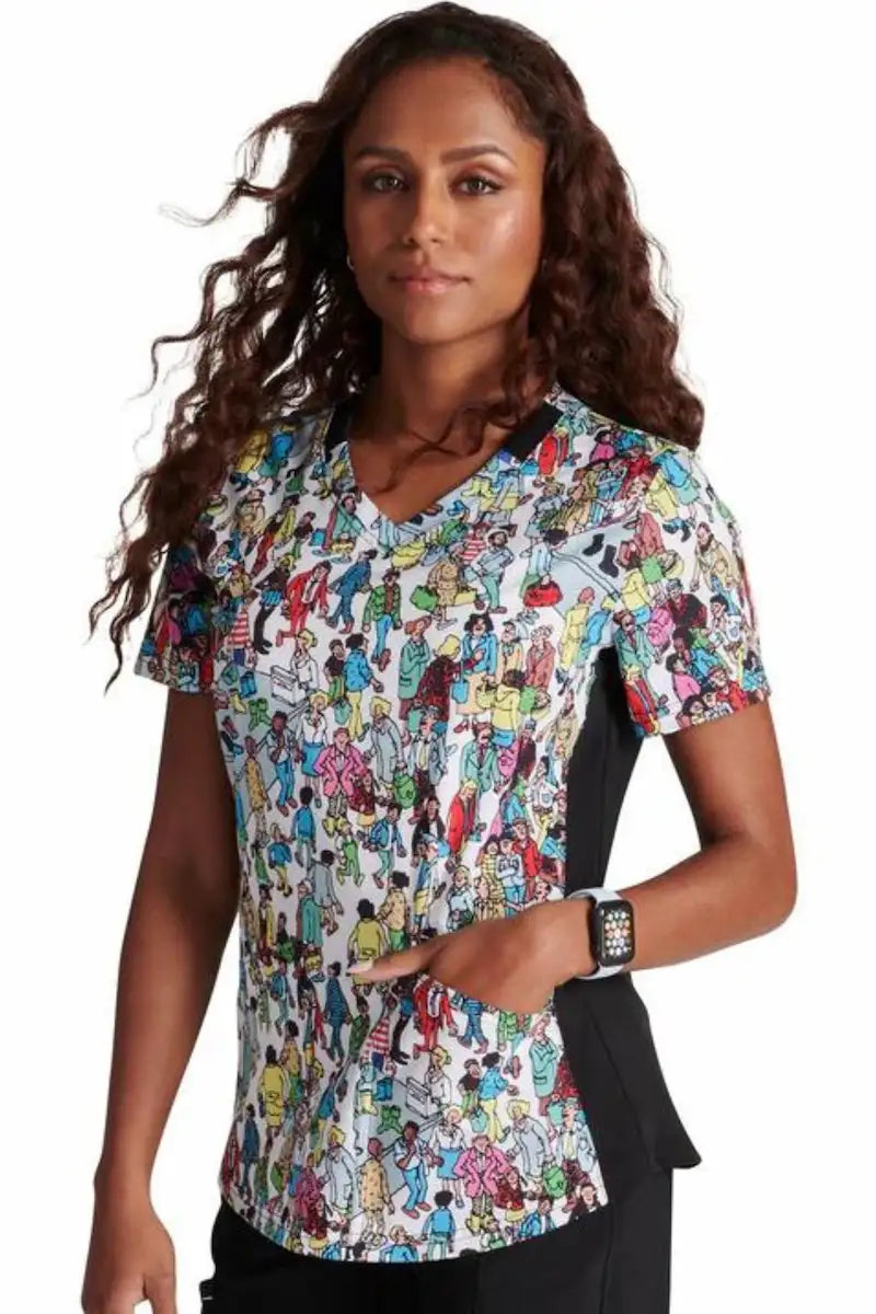 A look at the left side of the Tooniforms Women's V-Neck Print Scrub Top in Where's Waldo featuring two front patch pockets.