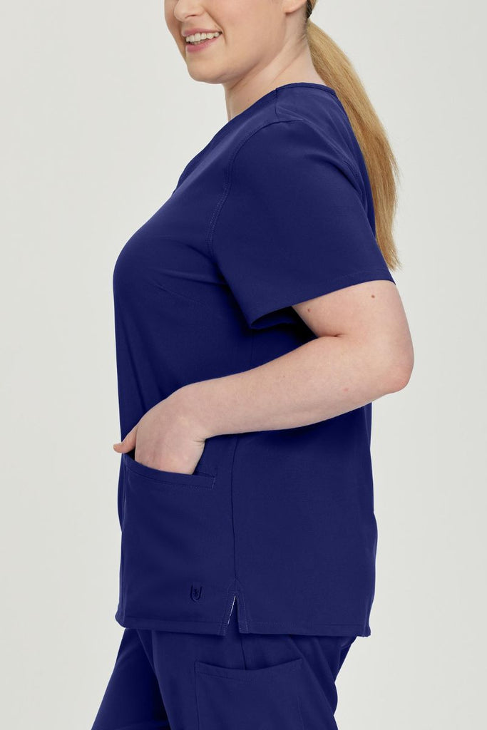 The side of the Urbane Performance Women's Motivate V-neck Scrub Top in True Navy size 3XL featuring two front angled welt pockets.