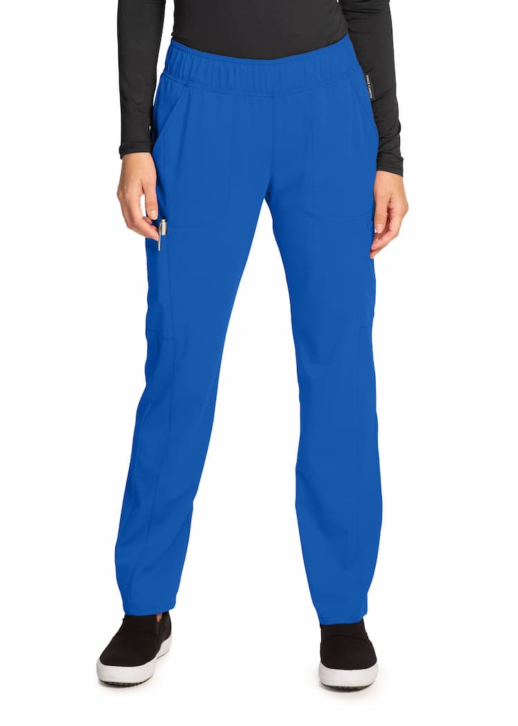 An image of a young female Nurse Practitioner wearing a Vince Camuto Women's Mid Rise Pull-On Scrub Pant in Royal size XL Tall featuring a total of 6 pockets.
