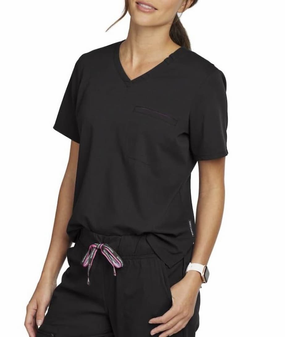 An image of a oyung female LPN wearing a Vince Camuto Women's Tuckable Scrub Top in Black size 2XL featuring a soft & stretchy twill fabric to ensure a comfortable all day fit.