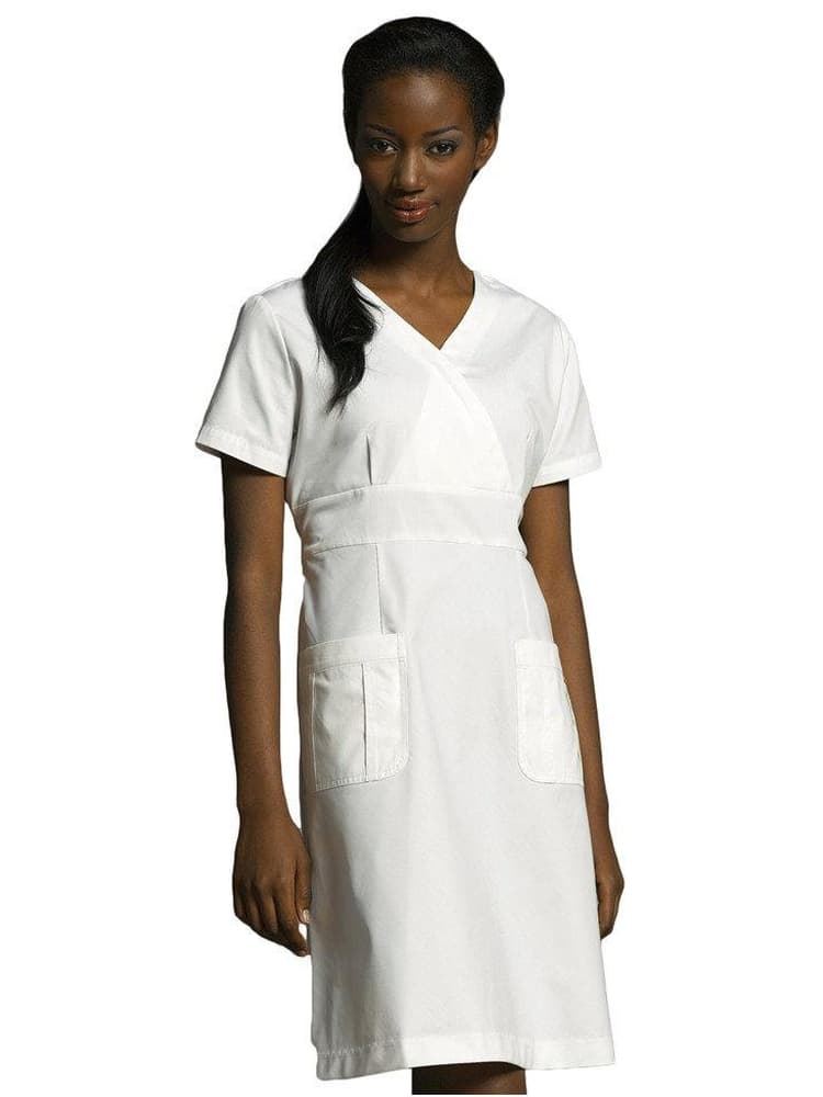 Nursing student wearing White Cross women's A-line Scrub Dress in white size medium featuring 2 front patch pockets.